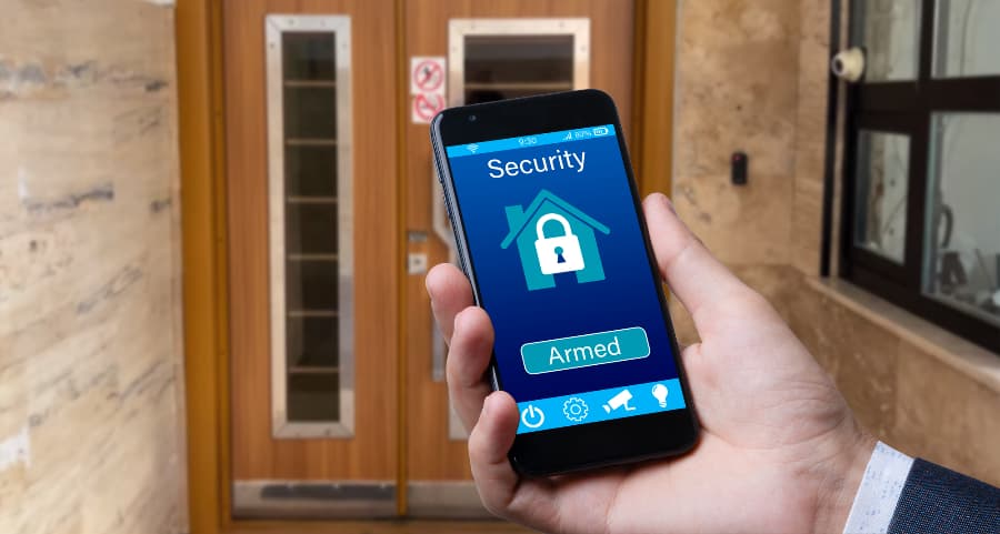 Man using smartphone to arm a security system